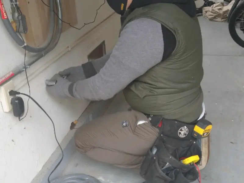 Electrician performing outlet wiring in a Fair Haven garage